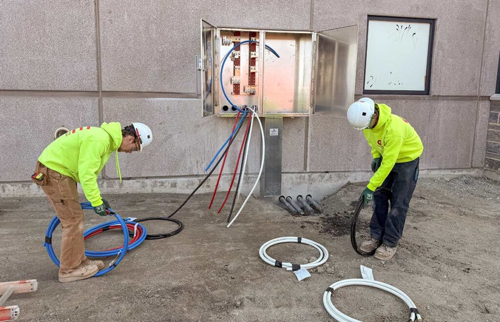 Two electrians installing an electrical panel at a commercial business in wisconsin.